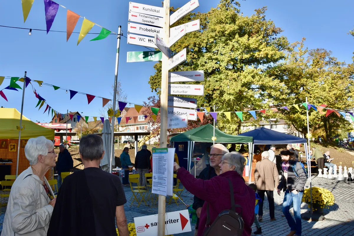 Noch ist vieles neu: Ein Wegweiser sorgte bei den Besucherinnen und Besuchern für Orientierung. Vier Personen betrachten Informationen an einem Wegweiser.
